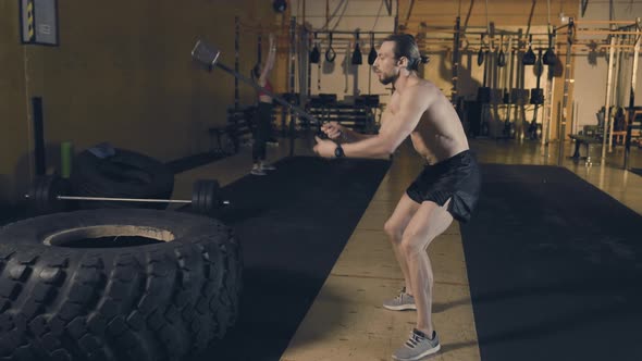 Man Hitting Tire with Sledgehammer