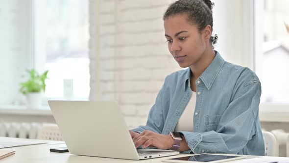 Young African Woman Working and Smiling at Camera