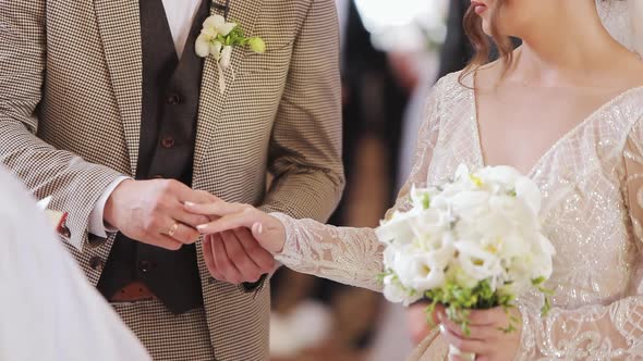 Groom Putting on the Wedding Ring on the Finger of His Bride's Finger During the Ceremony