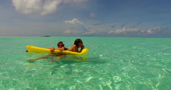 Fun man and woman on romantic honeymoon enjoy luxury on beach on clean white sand 4K background