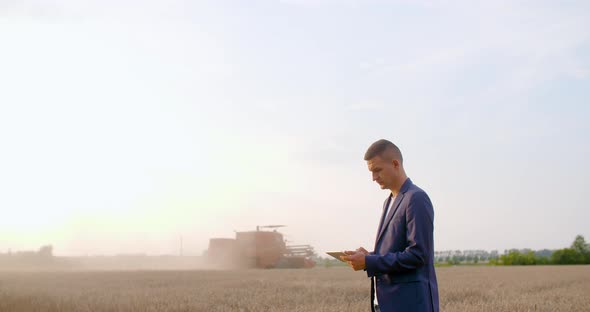 Agriculture - Farmer Using Digital Tablet During Harvesting