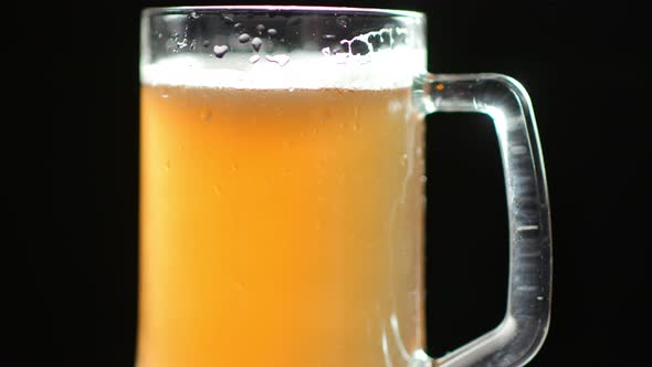Performance of Beautiful Fresh Beer with Bubbles and Foam in Glass Mug Covered Water Drops
