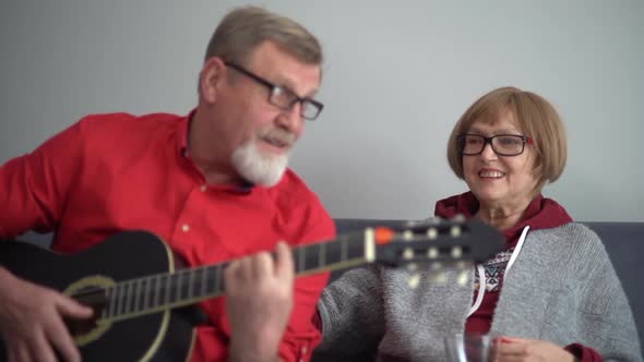 Elderly Couple Husband and Wife Singing at Home While Sitting on the Couch