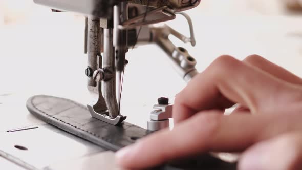 The Craftsman Stitches a Men's Leather Belt on a Sewing Machine