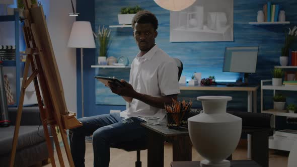 Black Man with Artistic Skills Using Tablet for Vase Design