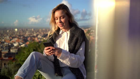 Happy woman writing text message on smartphone