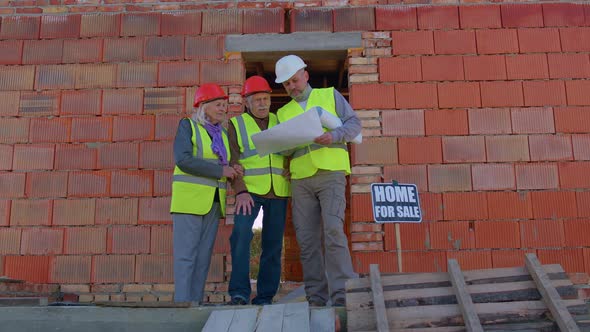 Realestate Agent Selling New House to Senior Grandmother Grandfather Showing Building Blueprints