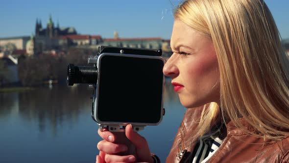 A Young Attractive Woman Shoots a Video with a Camera - Face Closeup From the Side