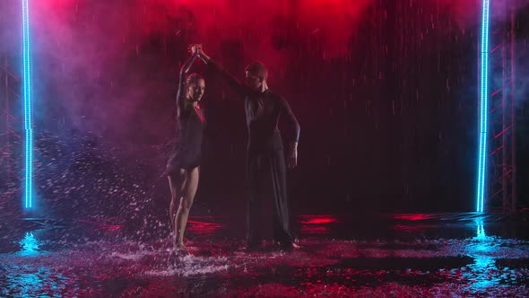 Jive Elements Performed By a Passionate Couple in the Rain. Photographed in a Dark Studio Against a