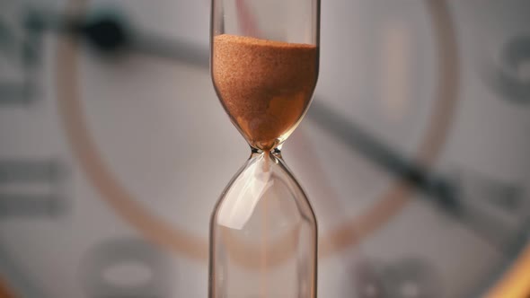 Hourglass Closeup is Pouring Against the Background Ordinary Mechanical Watch