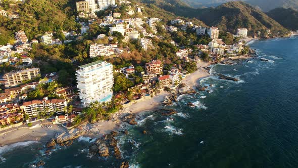 blue ocean waves crashing on the coastline beach of Playa Amapas in Puerto Vallarta Mexico at sunset