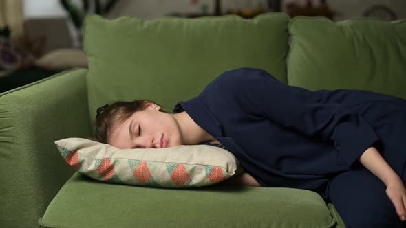 woman after work falls with a pillow on the sofa, she sleeps on the go