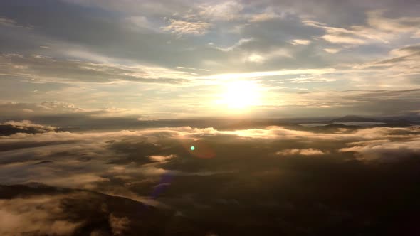 Above Clouds Against Sun, Aerial Drone Pan Right, Flying in the Sky