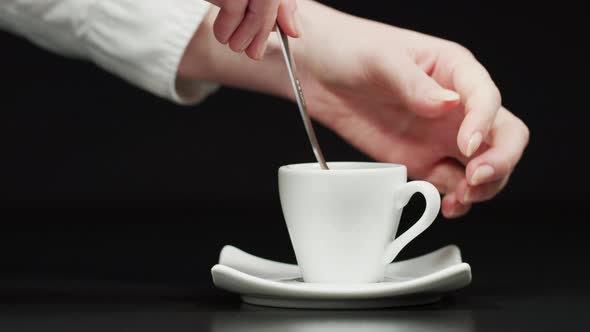 Hand stirring a cup of coffee