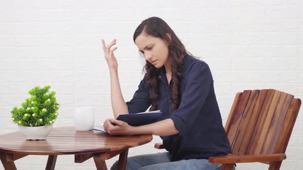 Shocked Indian girl reading a book at a cafe