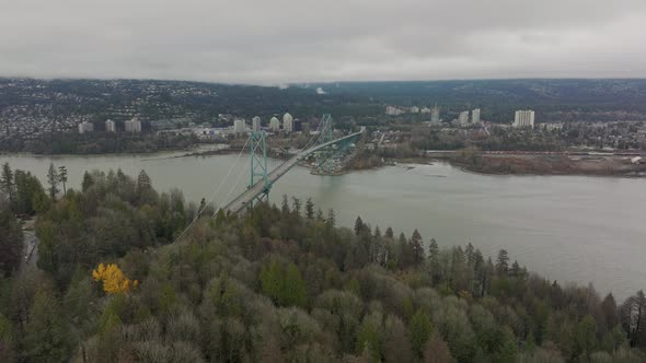 Drone Aerial Shot flying towards North Vancouver cityscape passing the Lions Gate Bridge in 4K