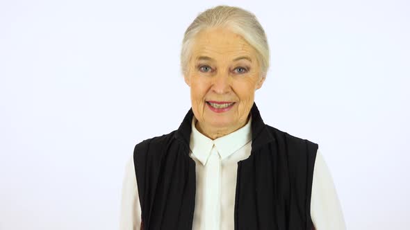 An elderly woman talks to the camera - white screen studio