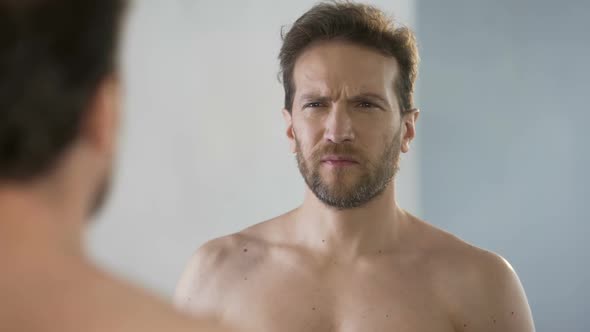 Sleepy Man Yawning and Looking in Mirror, Feeling Bad After Sleepless Night