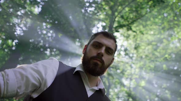 The Bartender Pours Alcohol From a Bottle in Sunny Weather in the Woods