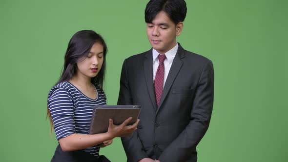 Young Handsome Asian Businessman and Young Asian Woman Working Together