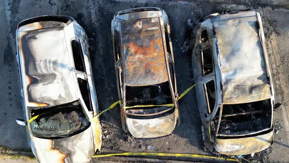 Burned cars in a city parking, overhead aerial view