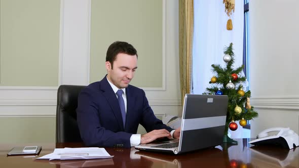 Businessman in a Good Mood Working on Laptop Computer in the Office