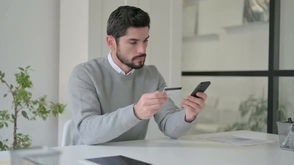 Young Man Making Online Payment on Smartphone