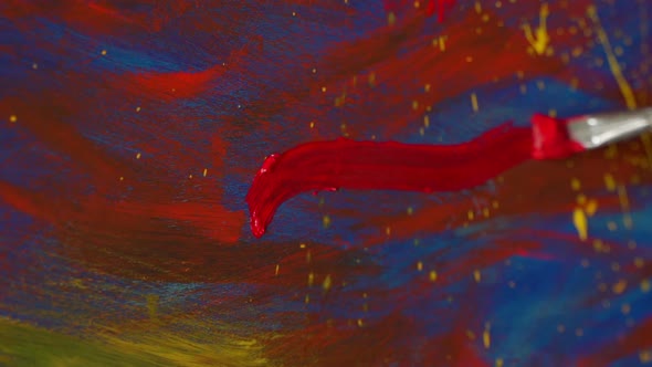 Closeup of a Female Artist's Hand Drawing with a Brush in Red