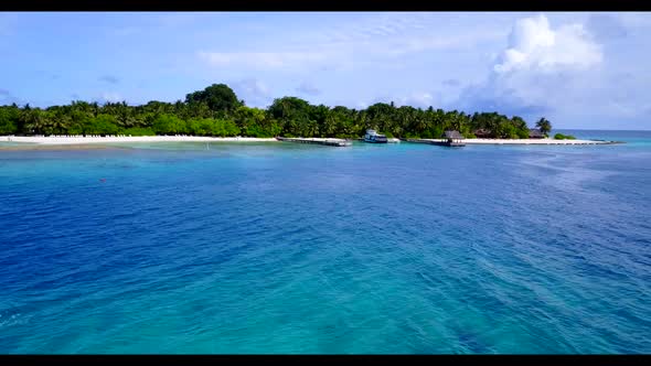 Aerial drone shot texture of idyllic coast beach trip by blue water with white sandy background of a