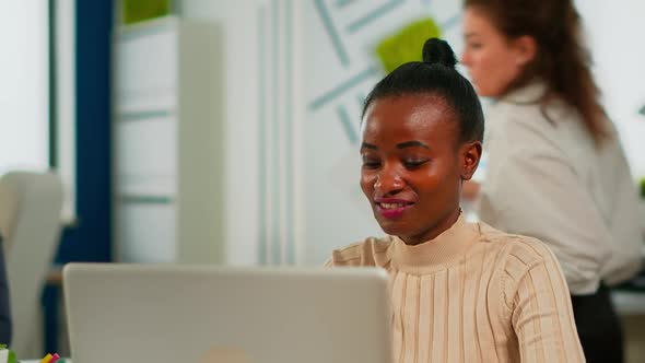 Portrait of Delighted African Business Woman Reading Good News on Laptop