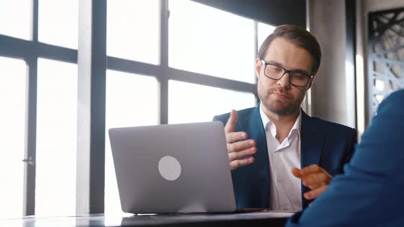 Young man in a suit interviewing a african american man in workplace