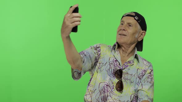 Senior Man Tourist Make a Photo on a Smartphone. Selfie. Handsome Old Man