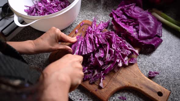 Chopping Red Cabbage On Wooden Chopping Board At The Kitchen. overhead