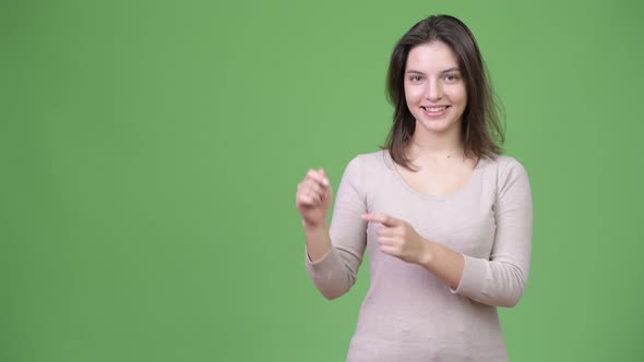 Young Happy Beautiful Woman Showing Something While Pointing Finger Up