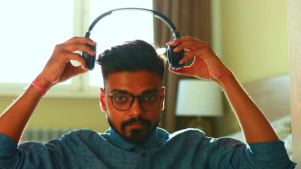 Indian Young Man Wearing Noise Canselling Headphones Relaxing Listening Personal Growth Training at
