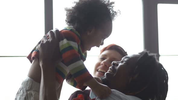 Joyful Interracial Family and Son Lounging at Home