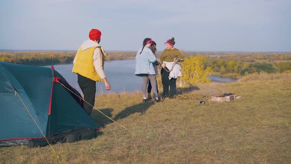 Guy Goes Out of Tent Stretches Arms and Girls Talk in Camp