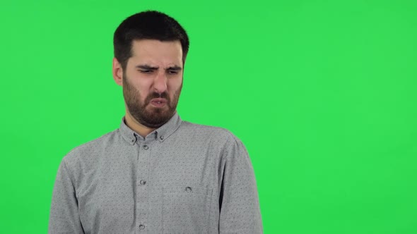 Portrait of Brunette Guy Is Showing Disgust for Bad Smell or Taste. Green Screen