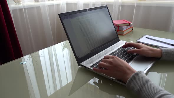 The girl working at home office hands on keyboard.