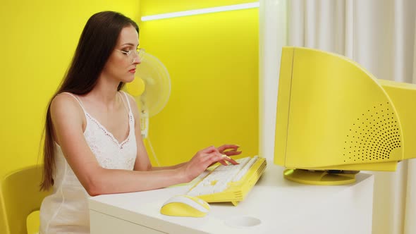 Woman In White Top Is Working at Yellow PC