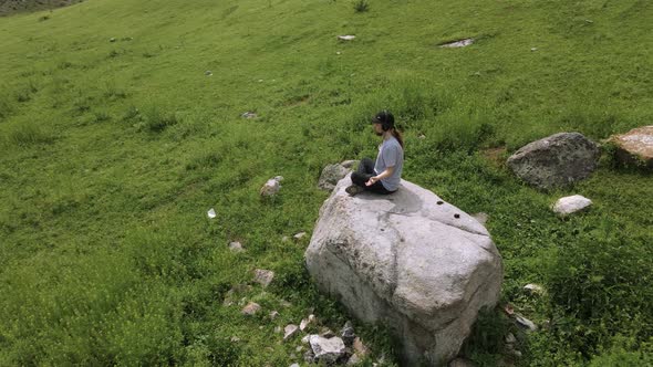 Young man preforms yoga in mountains in morning light