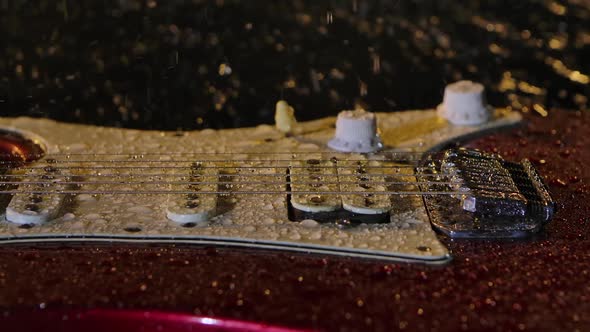 Camera Slides Over Electric Guitar Lies on Surface of Water Illuminated By Yellow Light in Dark