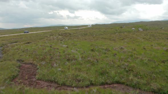 Low drone shot towards road through scottish countryside