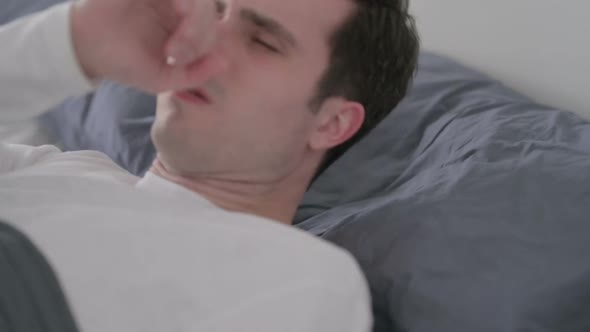 Man Coughing While Awake in Bed Close Up
