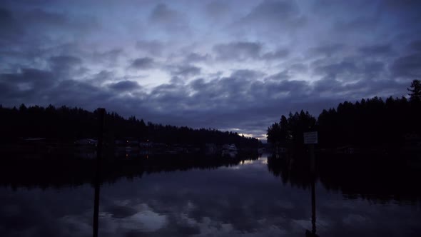 Blue hour time lapse of sunrise over Wollochet Bay near Gig Harbor, Washington, streaming clouds, pu