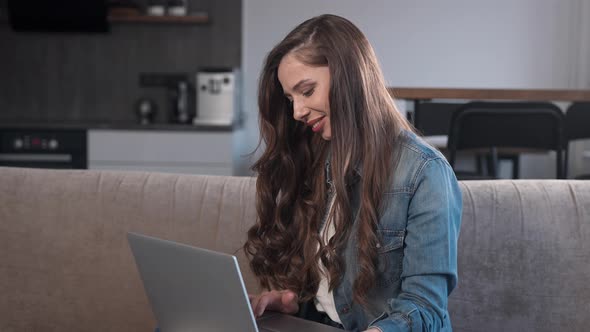 Attractive Brunette Working on a Laptop at Home