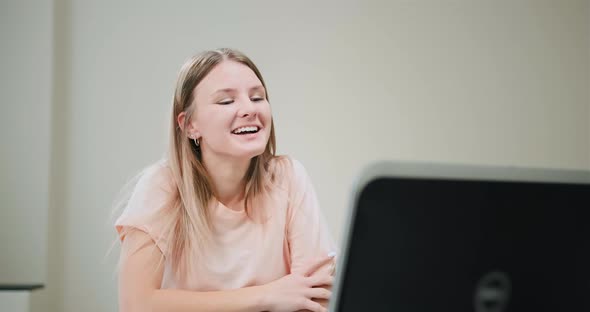 Young Woman Nods Talking with Friends Via Video Call at Home