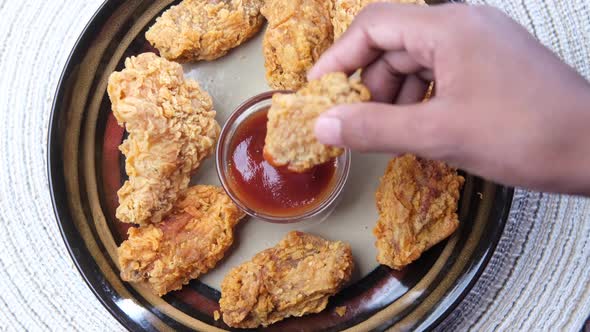 Eating Crispy Fried Chicken Wings on a Plate Top View