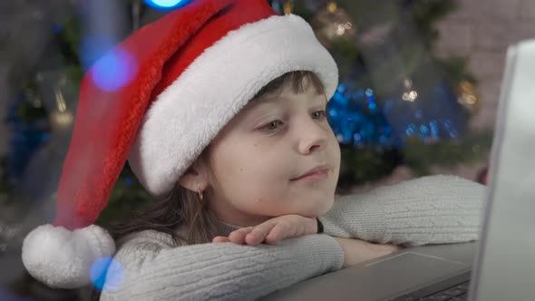 Child in isolation with a laptop at christmas. alt