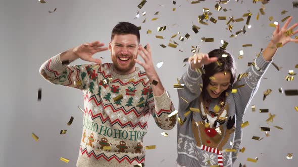 Happy Couple at Christmas Party Under Confetti